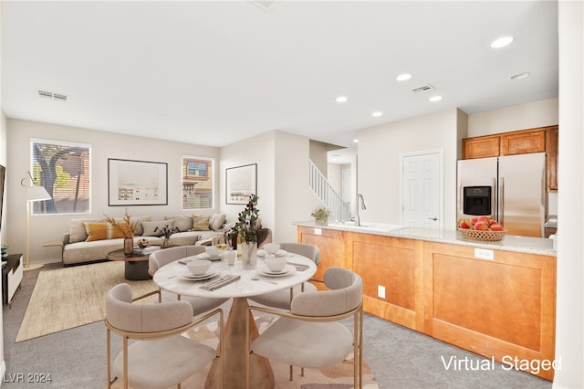 carpeted dining space featuring sink