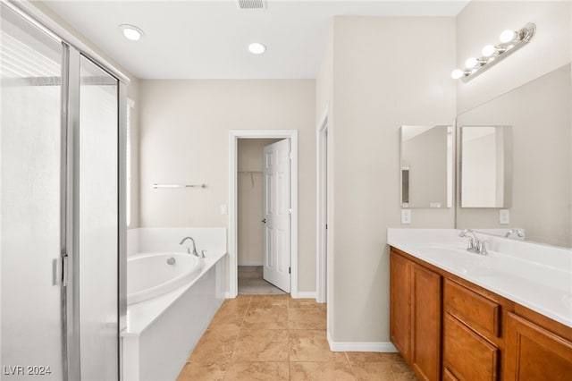 bathroom with tile patterned flooring, vanity, and shower with separate bathtub