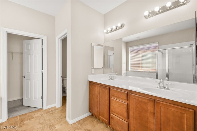 bathroom with tile patterned floors, vanity, toilet, and walk in shower