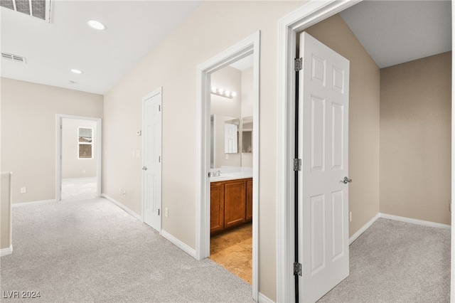 corridor with light colored carpet and sink