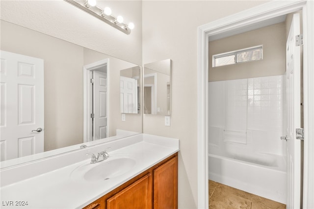 bathroom featuring tile patterned flooring, shower / bathing tub combination, and vanity