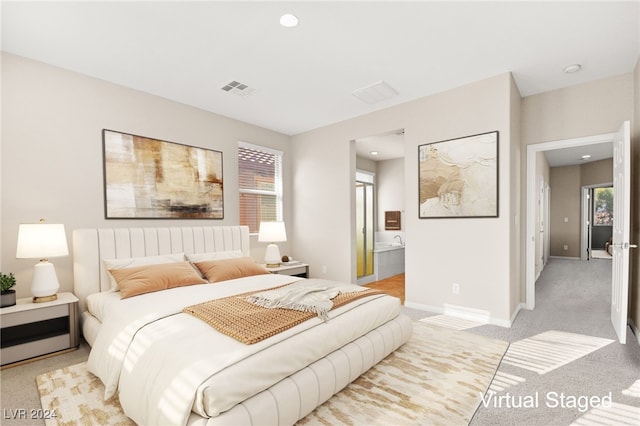 bedroom featuring ensuite bathroom and light colored carpet