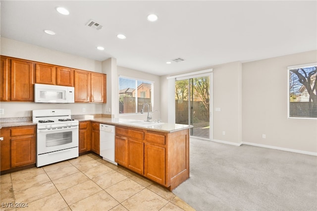 kitchen featuring light carpet, white appliances, kitchen peninsula, and sink