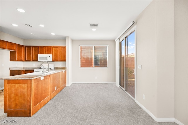 kitchen featuring kitchen peninsula, light colored carpet, and white appliances