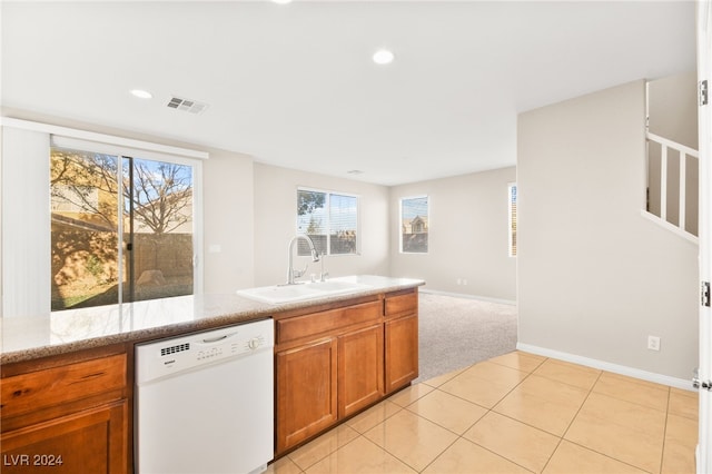 kitchen with light carpet, white dishwasher, light stone counters, and sink