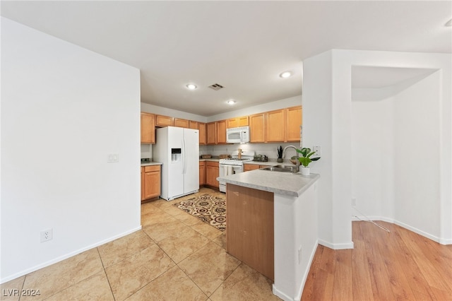 kitchen with kitchen peninsula, sink, and white appliances