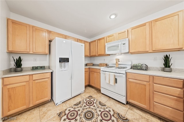 kitchen with light brown cabinets, light tile patterned flooring, and white appliances