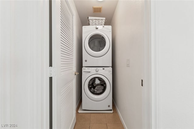 washroom with light tile patterned flooring and stacked washer / dryer