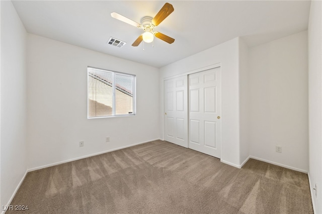 unfurnished bedroom with carpet flooring, ceiling fan, and a closet