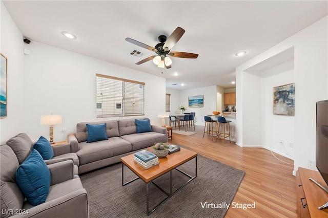 living room featuring hardwood / wood-style floors and ceiling fan