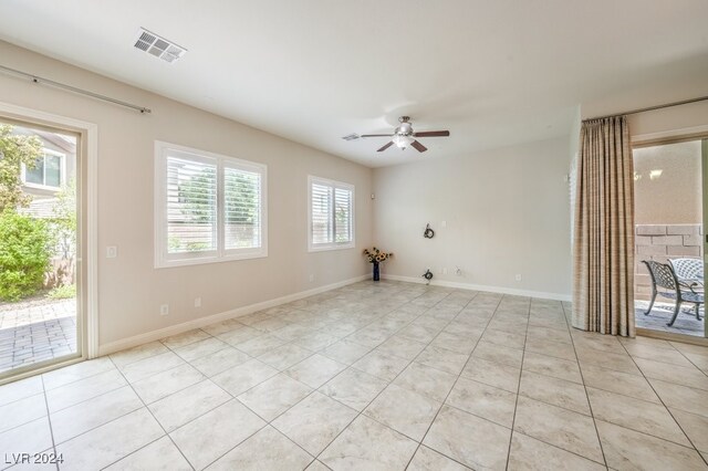 empty room with ceiling fan and light tile patterned floors