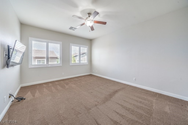 spare room with ceiling fan and light colored carpet