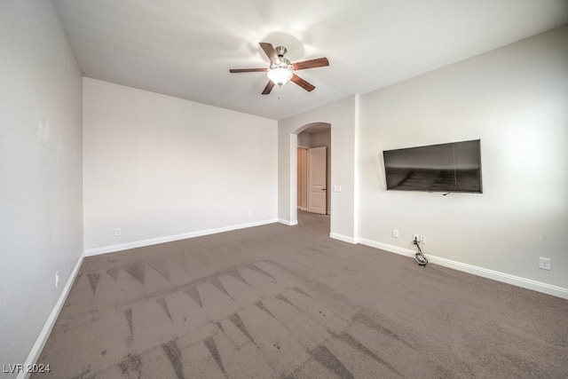 unfurnished living room with ceiling fan and dark carpet