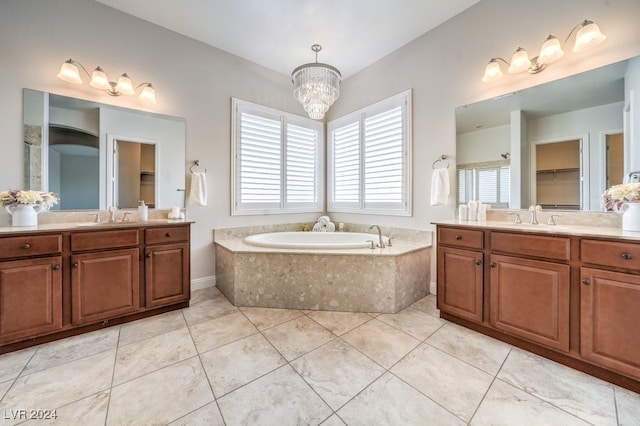 bathroom featuring tiled tub, tile patterned flooring, vanity, and an inviting chandelier