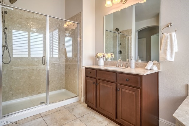 bathroom featuring tile patterned floors, vanity, and a shower with door