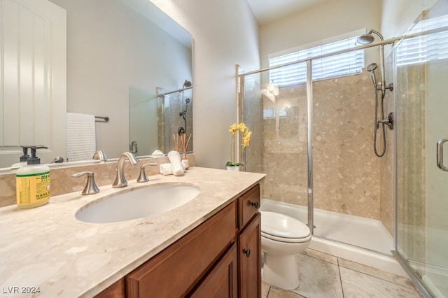 bathroom featuring tile patterned floors, vanity, toilet, and a shower with shower door