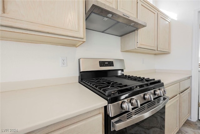 kitchen with stainless steel range with gas cooktop, light brown cabinets, and exhaust hood