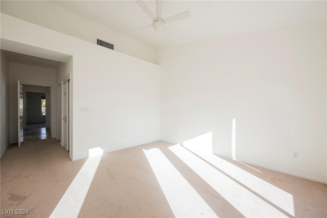 empty room with ceiling fan and light colored carpet