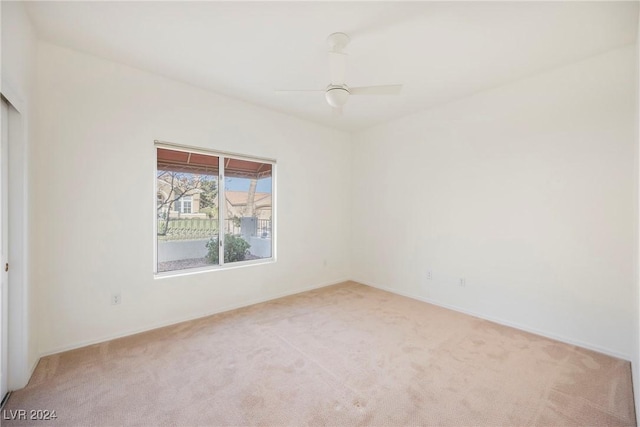 carpeted spare room with ceiling fan