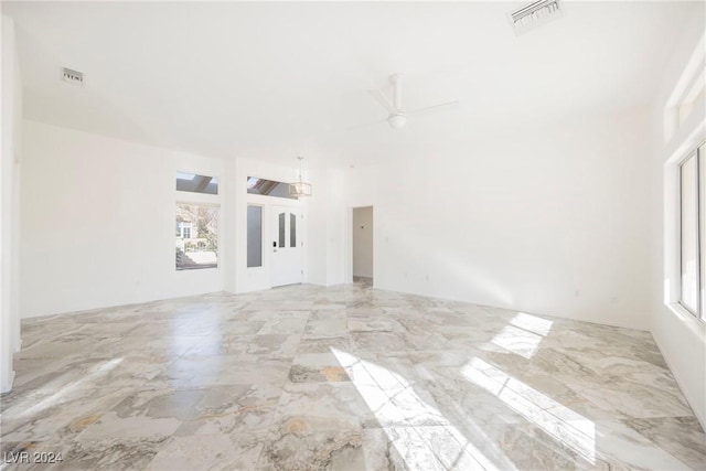 unfurnished living room featuring plenty of natural light and ceiling fan