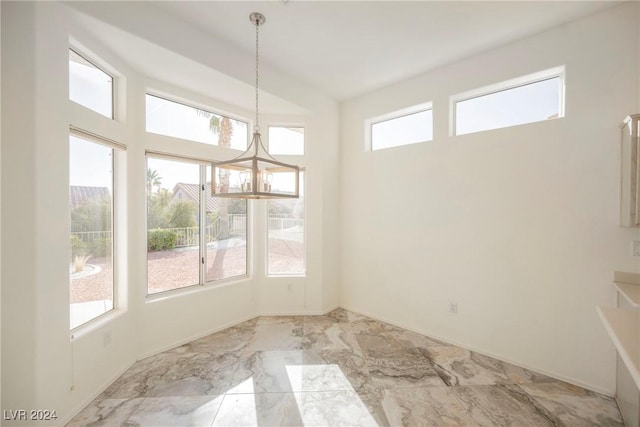 unfurnished dining area featuring a notable chandelier