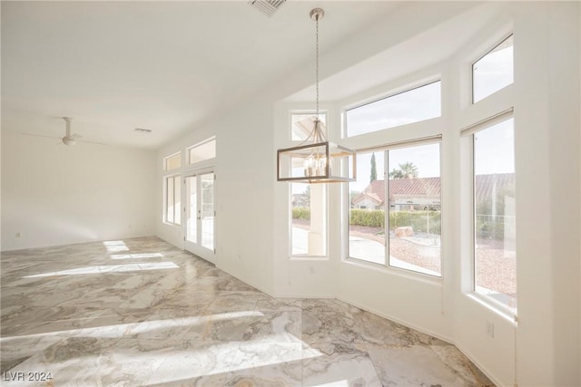 unfurnished room with ceiling fan with notable chandelier