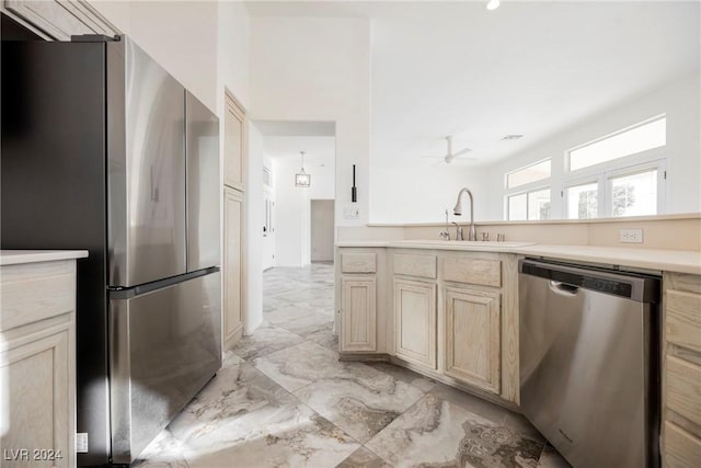 kitchen featuring appliances with stainless steel finishes, ceiling fan, light brown cabinetry, and sink