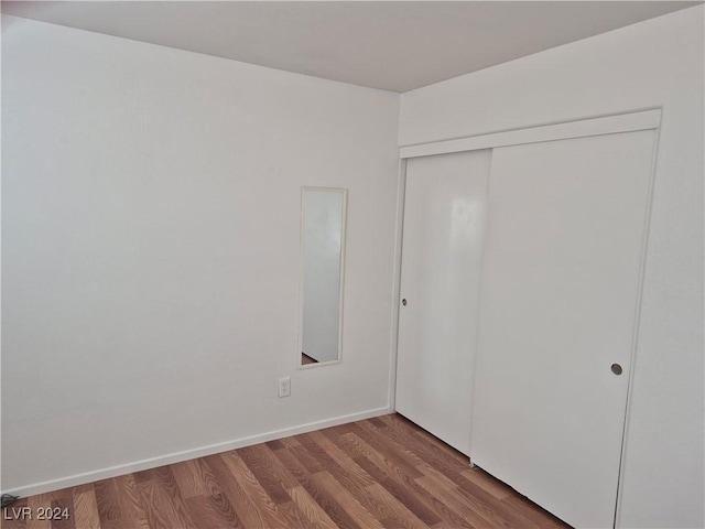 unfurnished bedroom featuring wood-type flooring and a closet