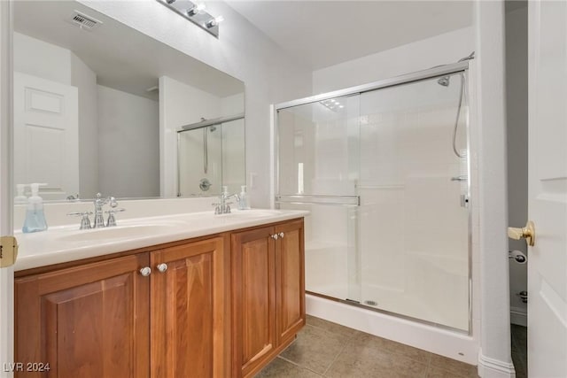 bathroom featuring tile patterned flooring, vanity, and an enclosed shower