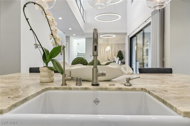 interior details featuring light stone counters and sink