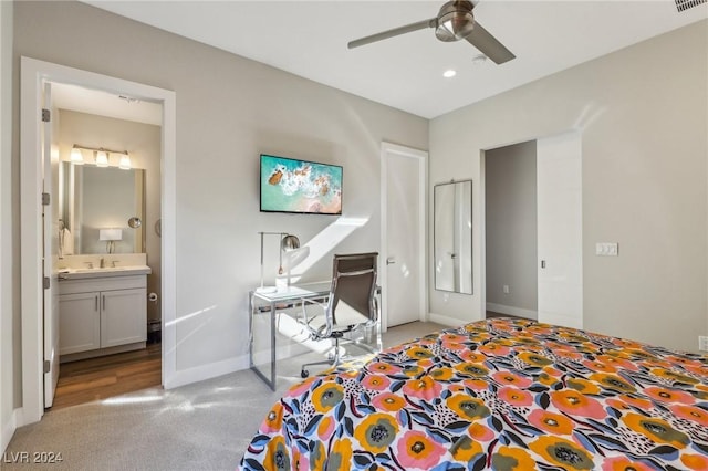 carpeted bedroom featuring connected bathroom, ceiling fan, and sink