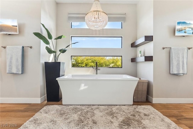 bathroom with wood-type flooring, a tub, and a chandelier