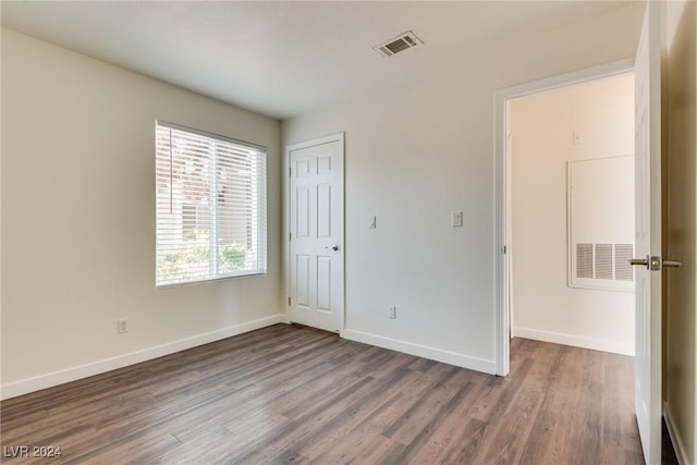 unfurnished bedroom with hardwood / wood-style floors and a closet