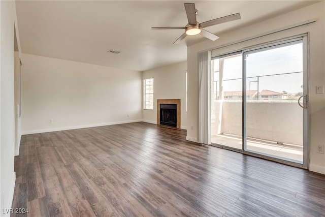 unfurnished living room featuring ceiling fan and dark wood-type flooring