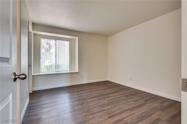 unfurnished room with dark wood-type flooring