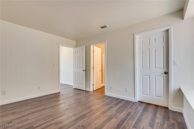 unfurnished bedroom with dark hardwood / wood-style flooring