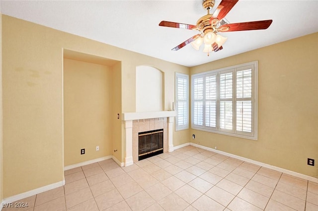 unfurnished living room with a tiled fireplace, ceiling fan, and light tile patterned floors