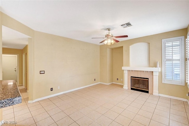 unfurnished living room featuring light tile patterned flooring, a fireplace, and ceiling fan