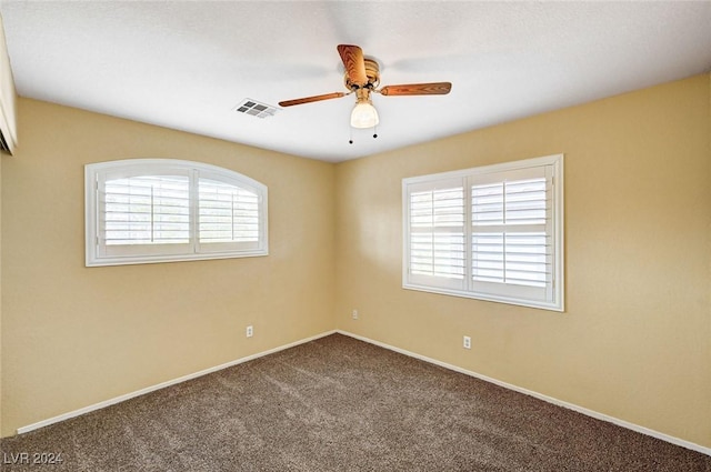 empty room featuring ceiling fan and carpet