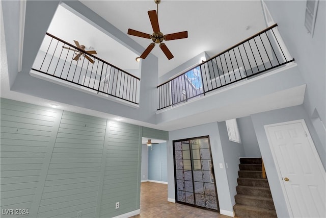 unfurnished living room featuring a high ceiling and ceiling fan