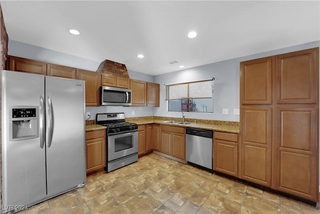 kitchen with light stone counters, sink, and appliances with stainless steel finishes