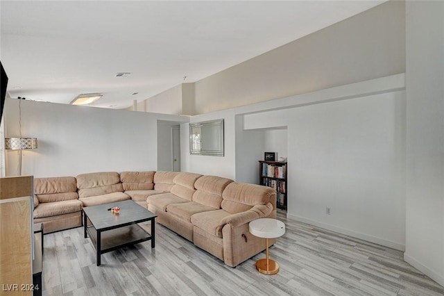 living room featuring light hardwood / wood-style floors and vaulted ceiling