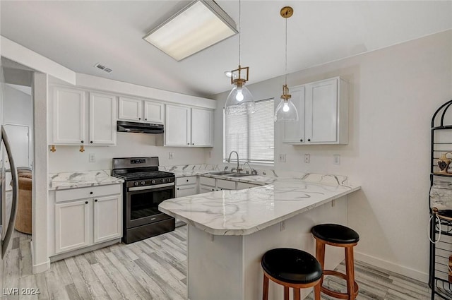 kitchen with stainless steel gas stove, sink, kitchen peninsula, a kitchen bar, and white cabinets