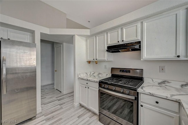 kitchen with white cabinetry, light stone counters, light hardwood / wood-style flooring, vaulted ceiling, and appliances with stainless steel finishes