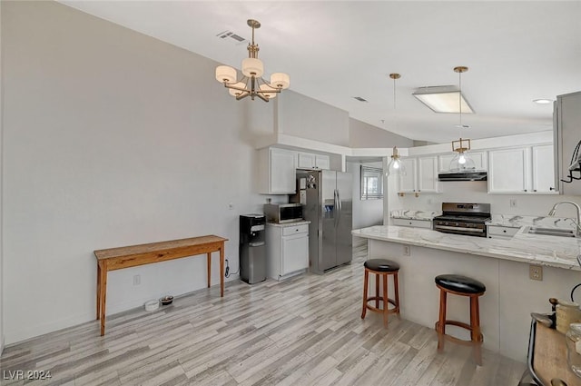 kitchen featuring kitchen peninsula, appliances with stainless steel finishes, hanging light fixtures, and lofted ceiling