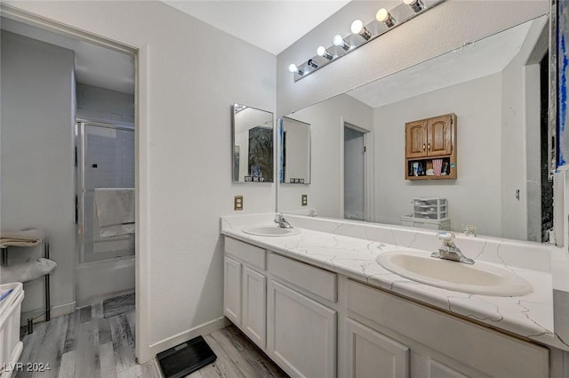 bathroom featuring hardwood / wood-style floors, vanity, and a shower with shower door