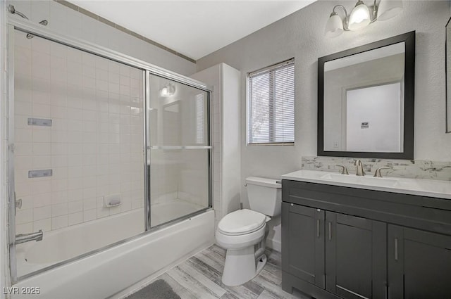 full bathroom with vanity, toilet, shower / bath combination with glass door, and wood-type flooring