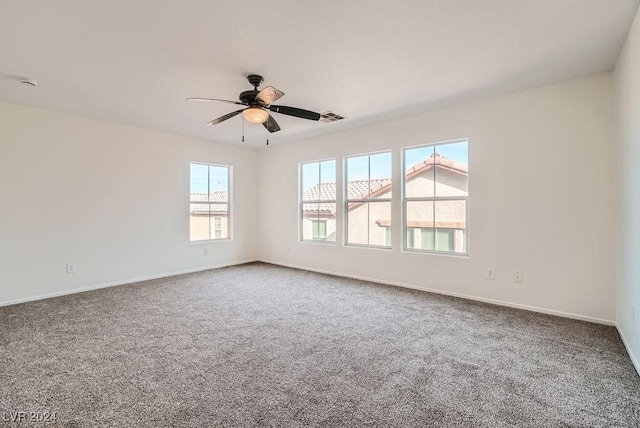 carpeted empty room featuring ceiling fan and a healthy amount of sunlight