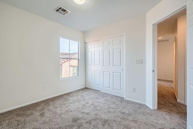 unfurnished bedroom with carpet flooring and a closet