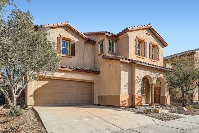 mediterranean / spanish home featuring a garage